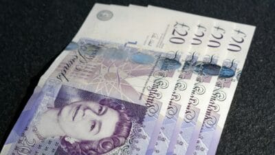 Brytyjskie banknoty 20 funtów ułożone na ciemnym tle, symbolizujące walutę Wielkiej Brytanii i finanse osobiste.