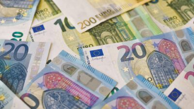 Zbliżenie na rozrzucone banknoty euro o różnych nominałach, w tym 20, 10, 100 i 200 euro, układające się w losowy wzór.